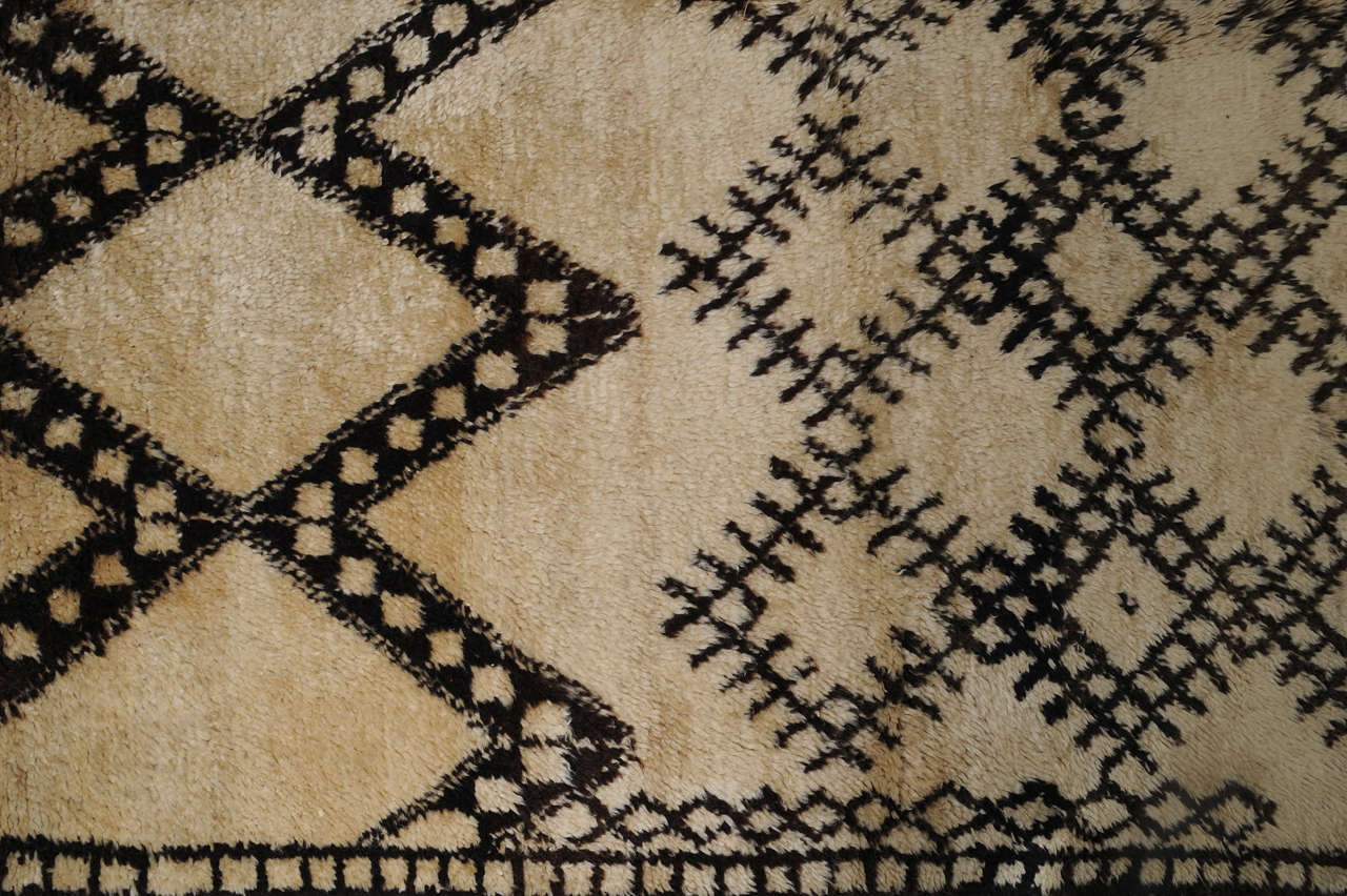 The carpets of the Beni Ouarain tribal confederacy differ from other Berber weavings in that they are woven exclusively with an ivory background and decorated with abstract geometric motifs of undyed natural wool. The high quality of the materials